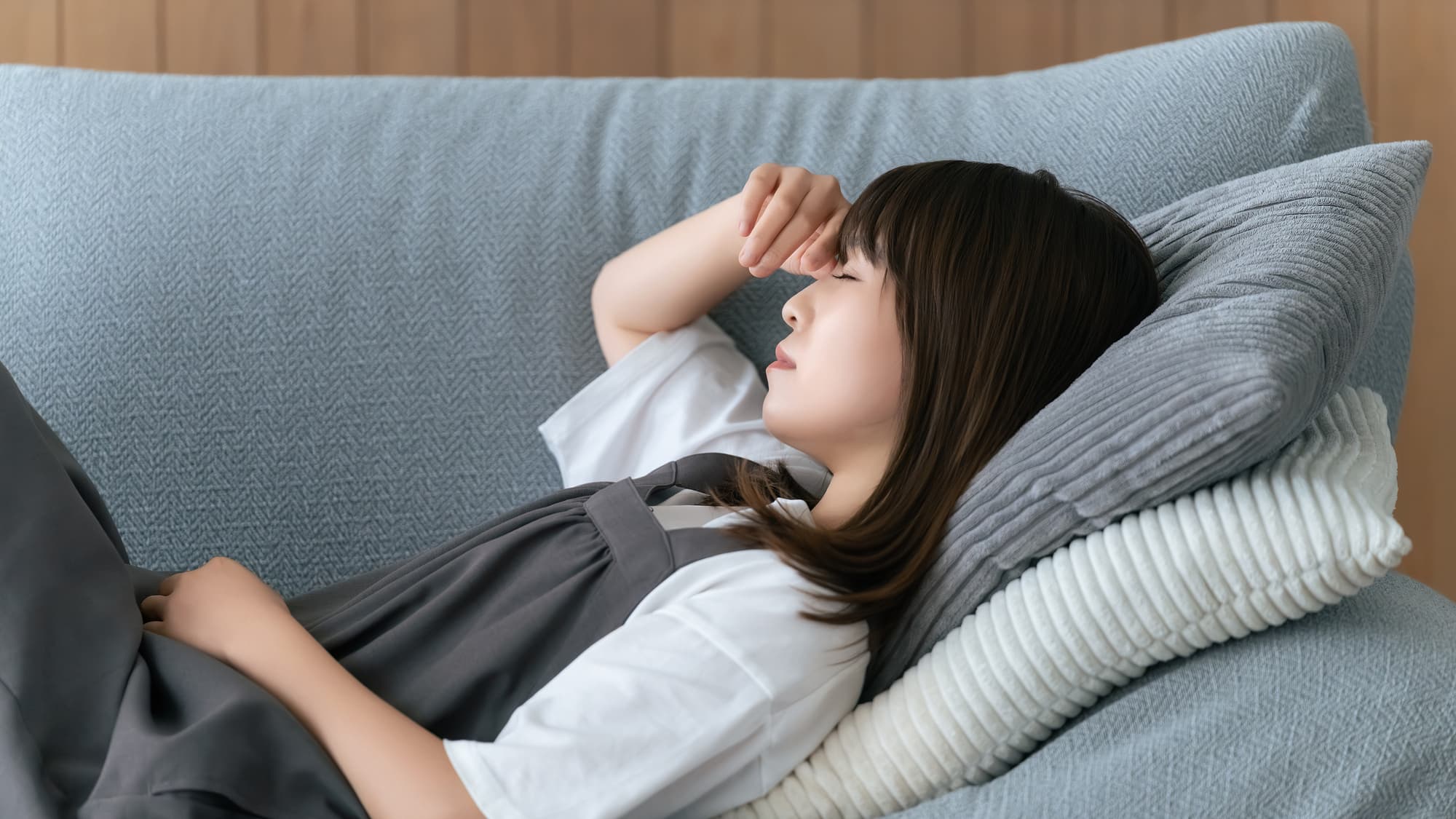 倦怠感を感じて横になる女性