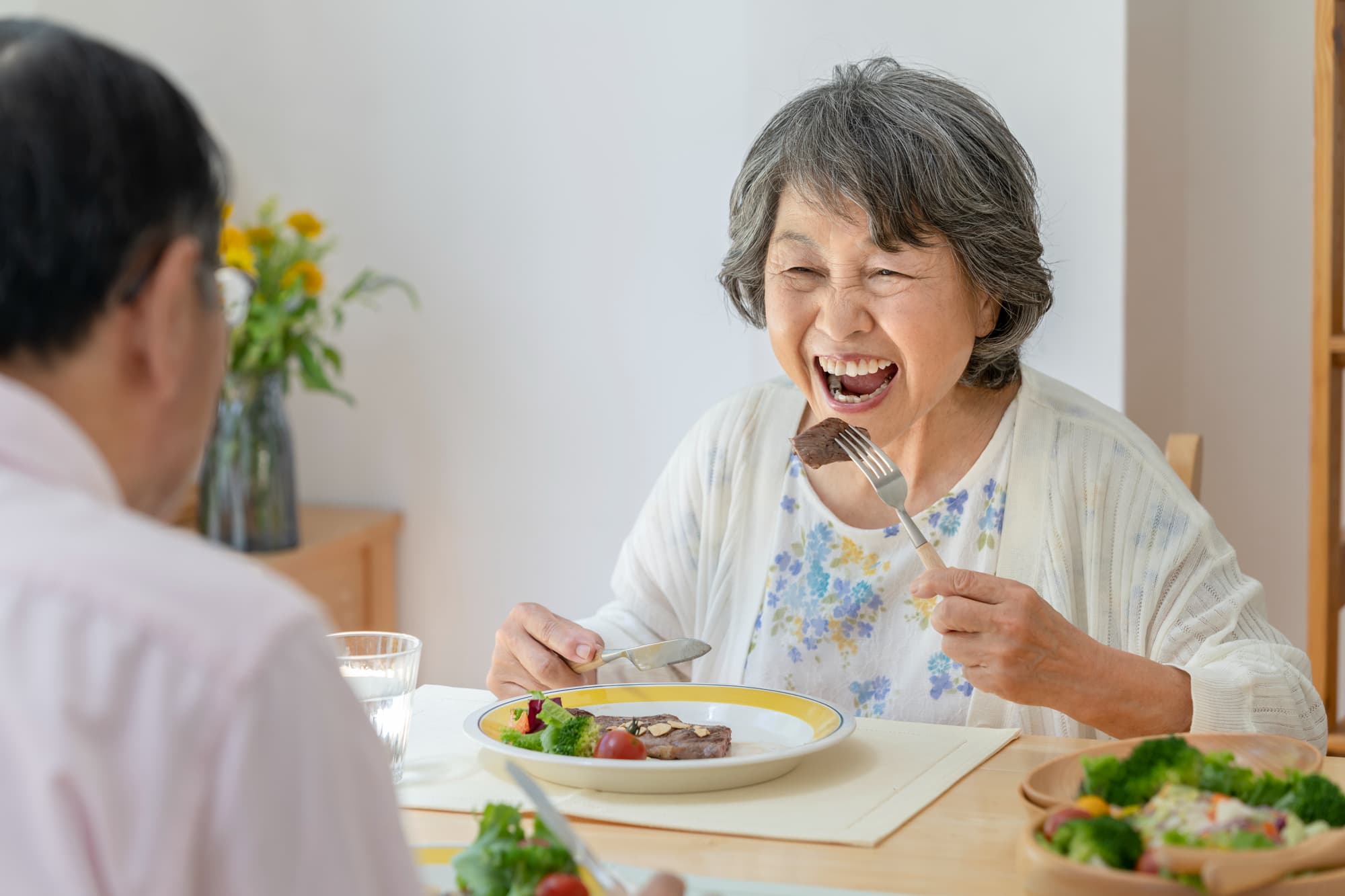 ステーキを食べる高齢女性