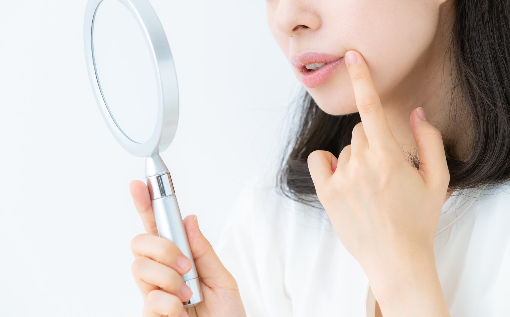 顔の歪みを確認する20代の女性