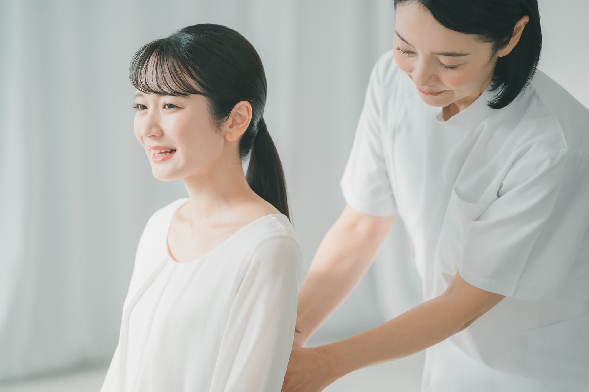 腰回りの筋肉をほぐしてもらう女性