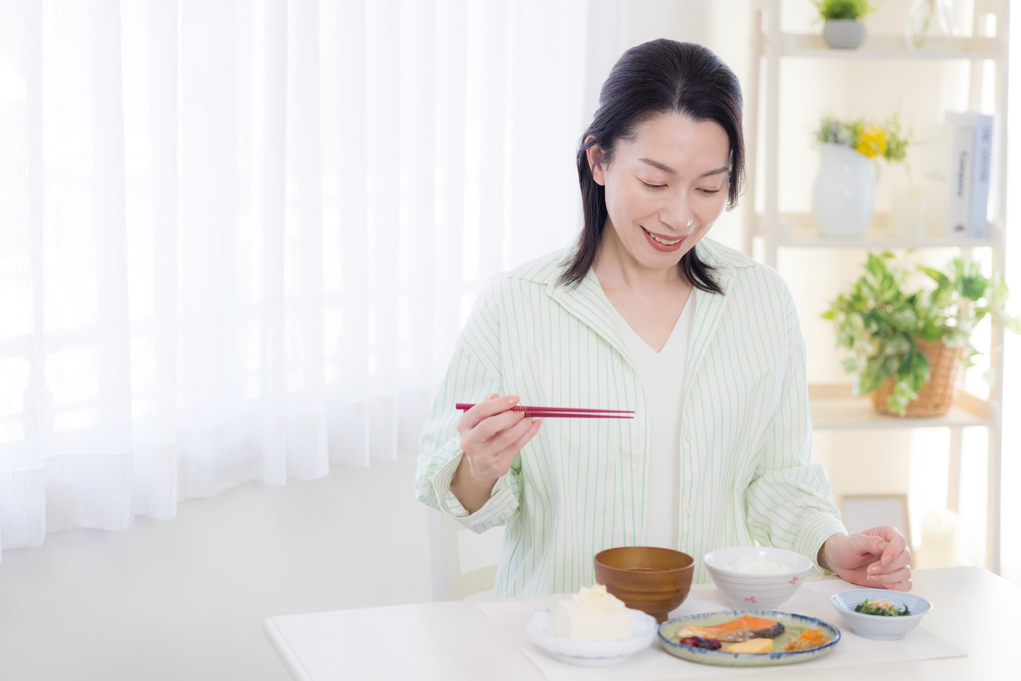 奥歯を治療して食事をする女性