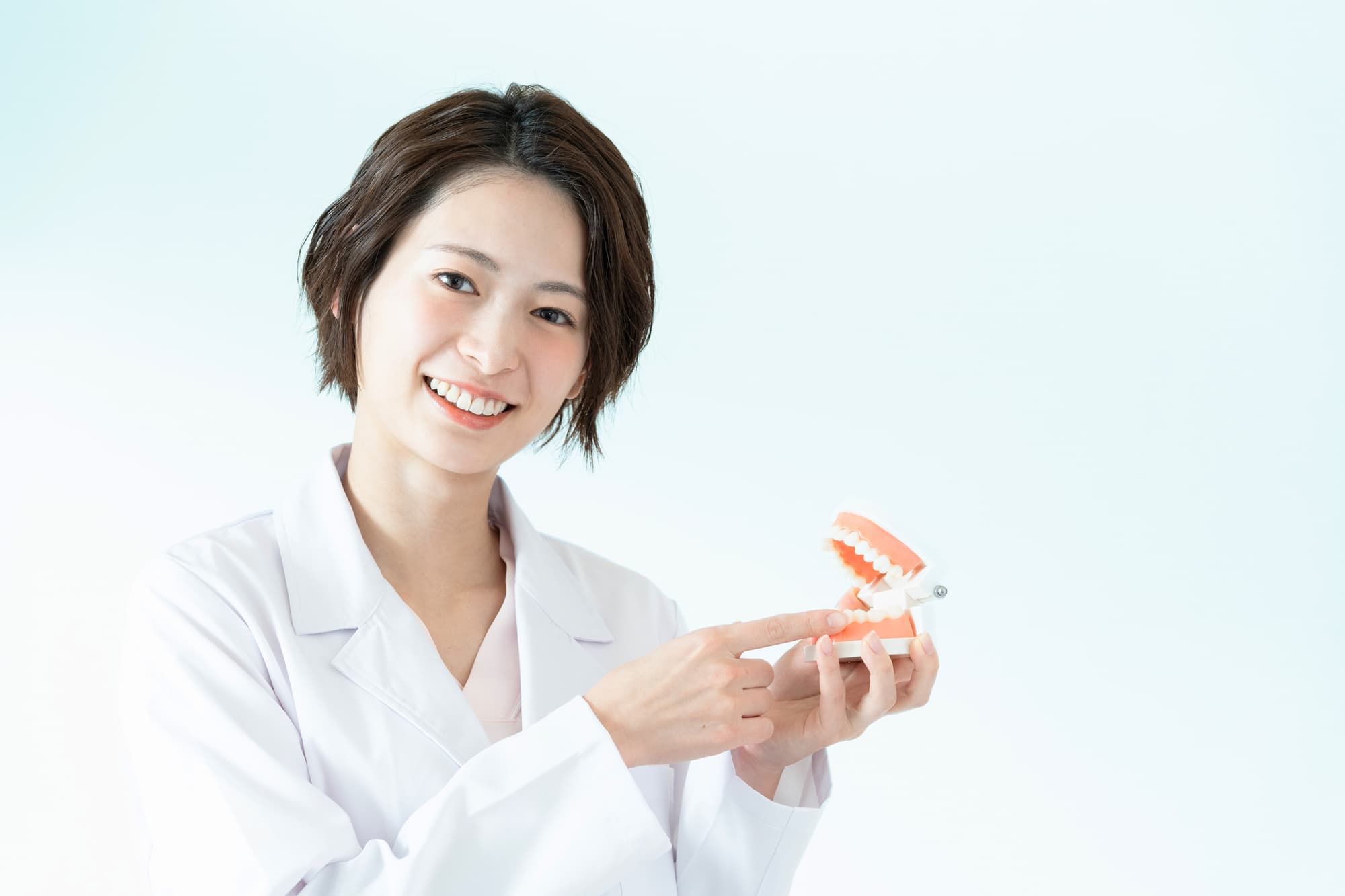 甘い嚙み合わせについて説明する歯科医師
