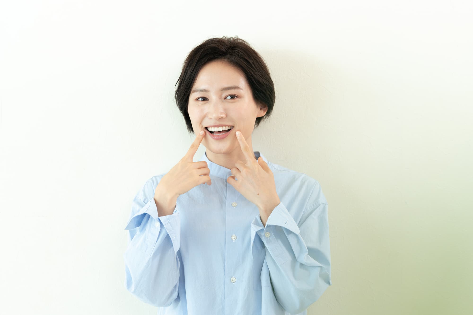 歯を指さす女性