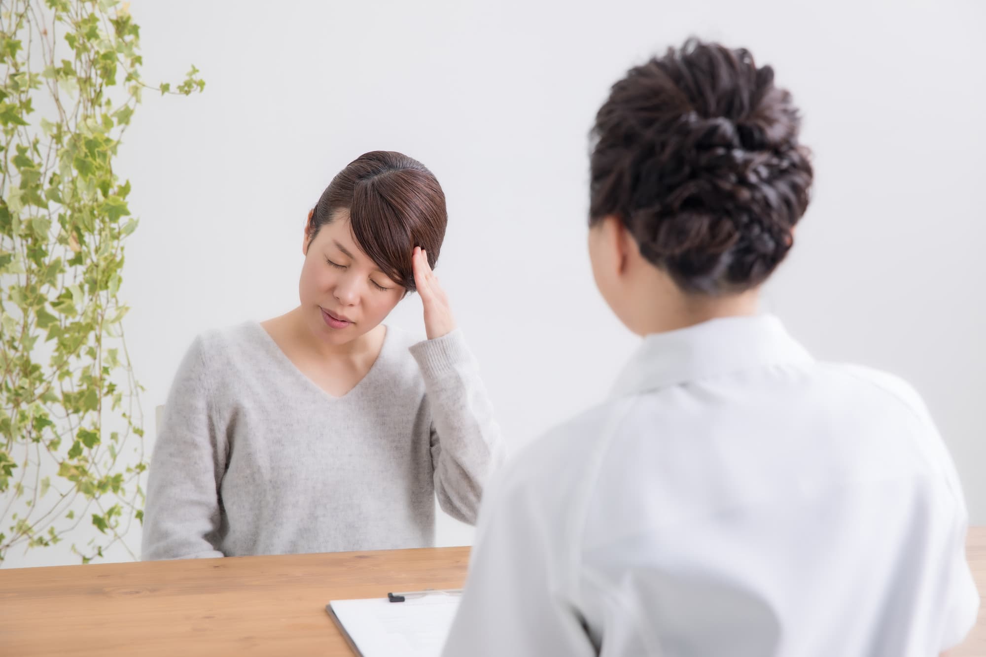 体調不良の原因が不明と言われ困惑する女性