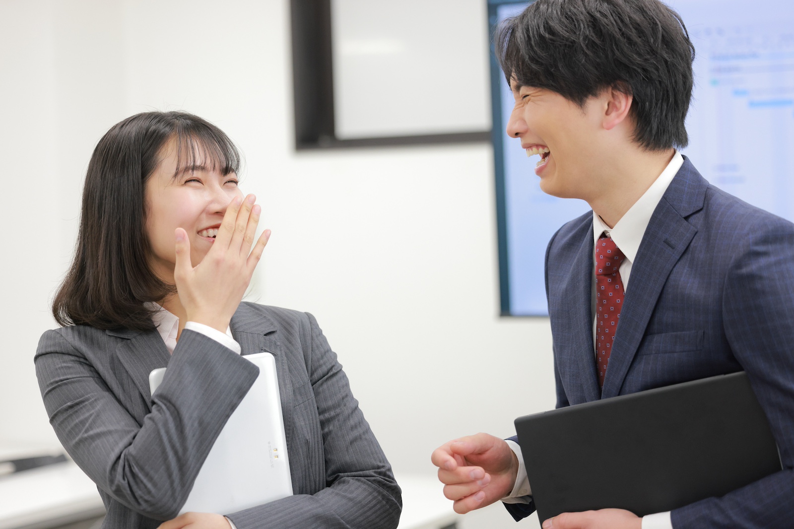 口元を隠して笑う女性と、よく笑う男性