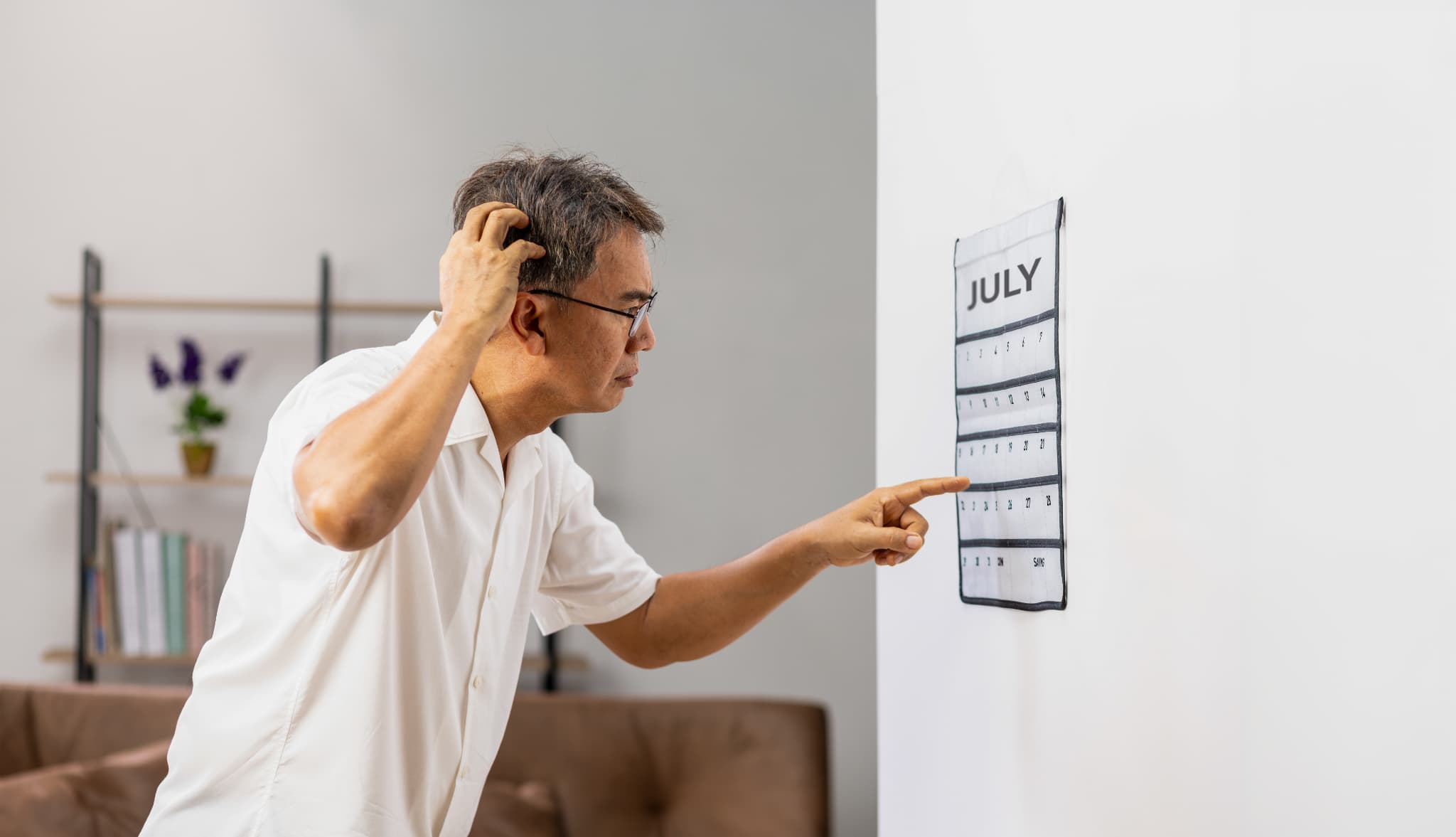 カレンダーを確認する高齢男性