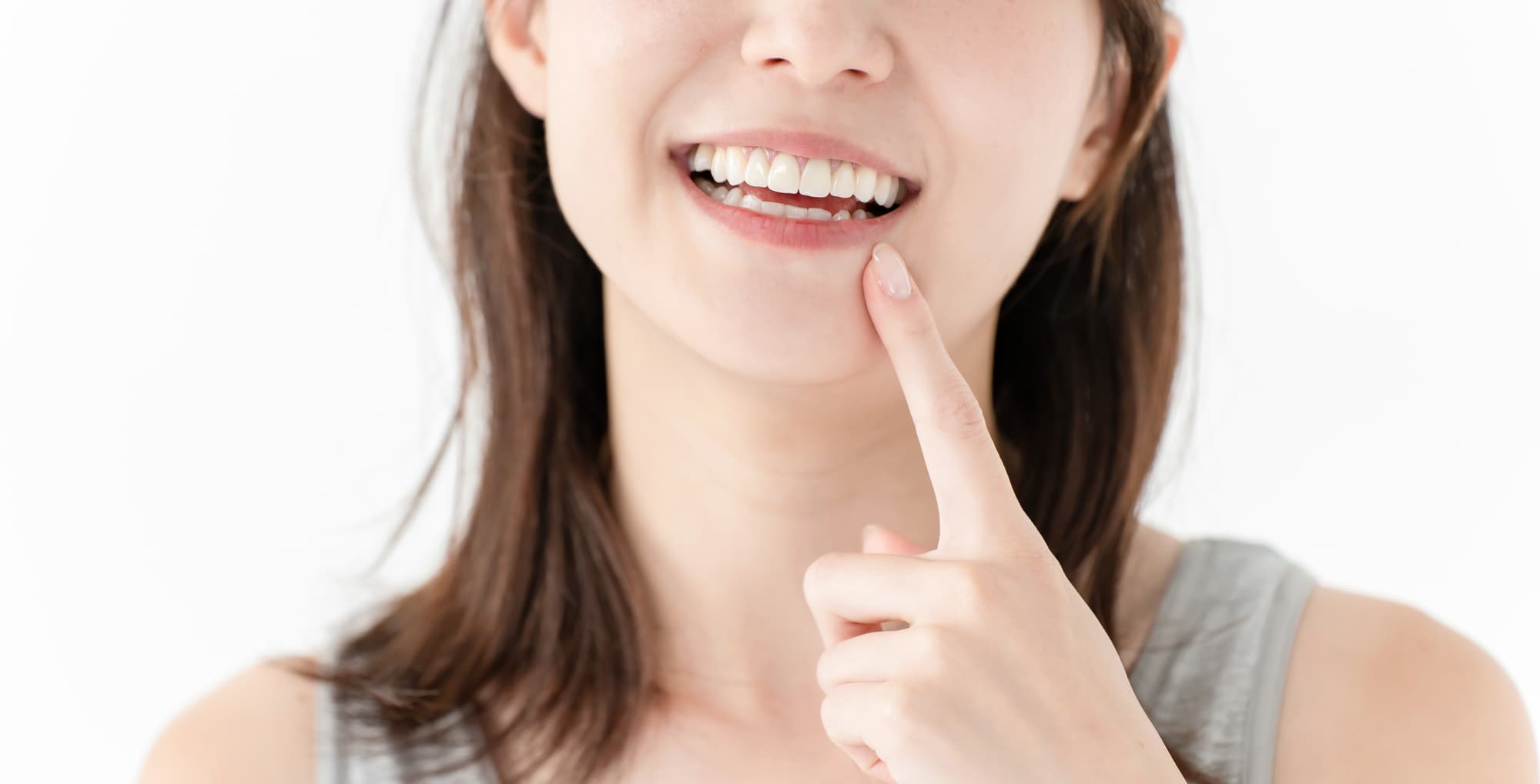 口元を指さして笑う女性