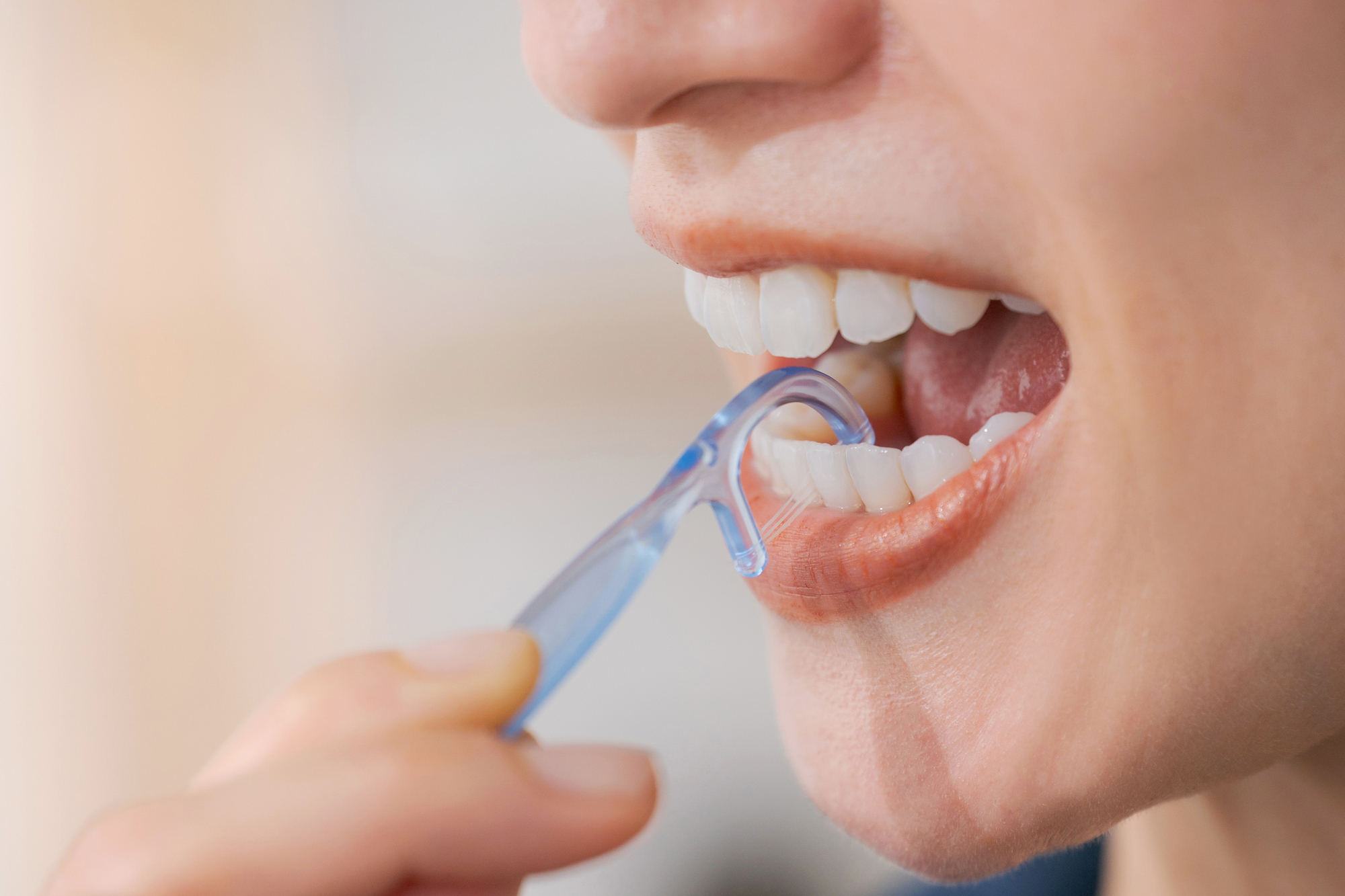 糸ようじを使っている女性