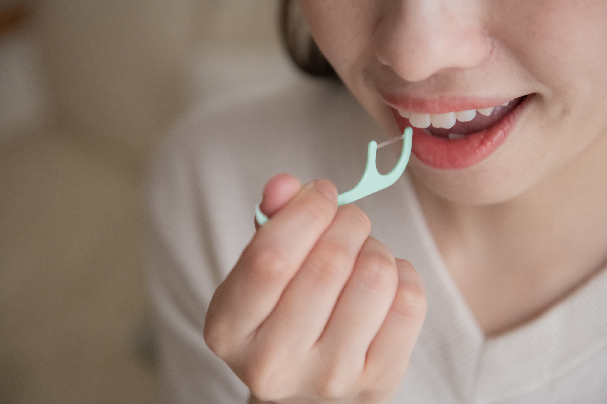 糸ようじを使っている女性