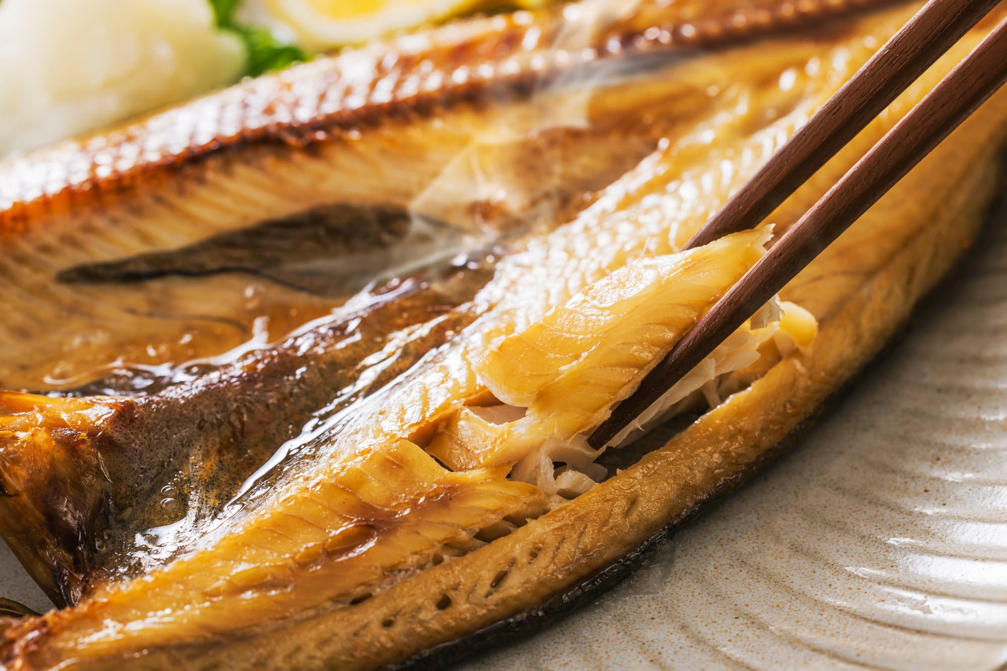 焼き魚を箸でほぐす様子