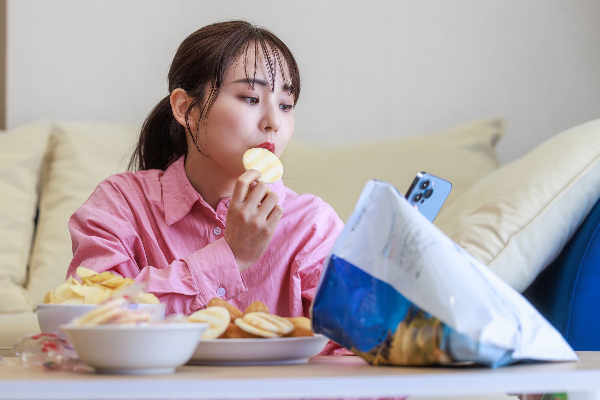 だらだらとお菓子をつまむ女性
