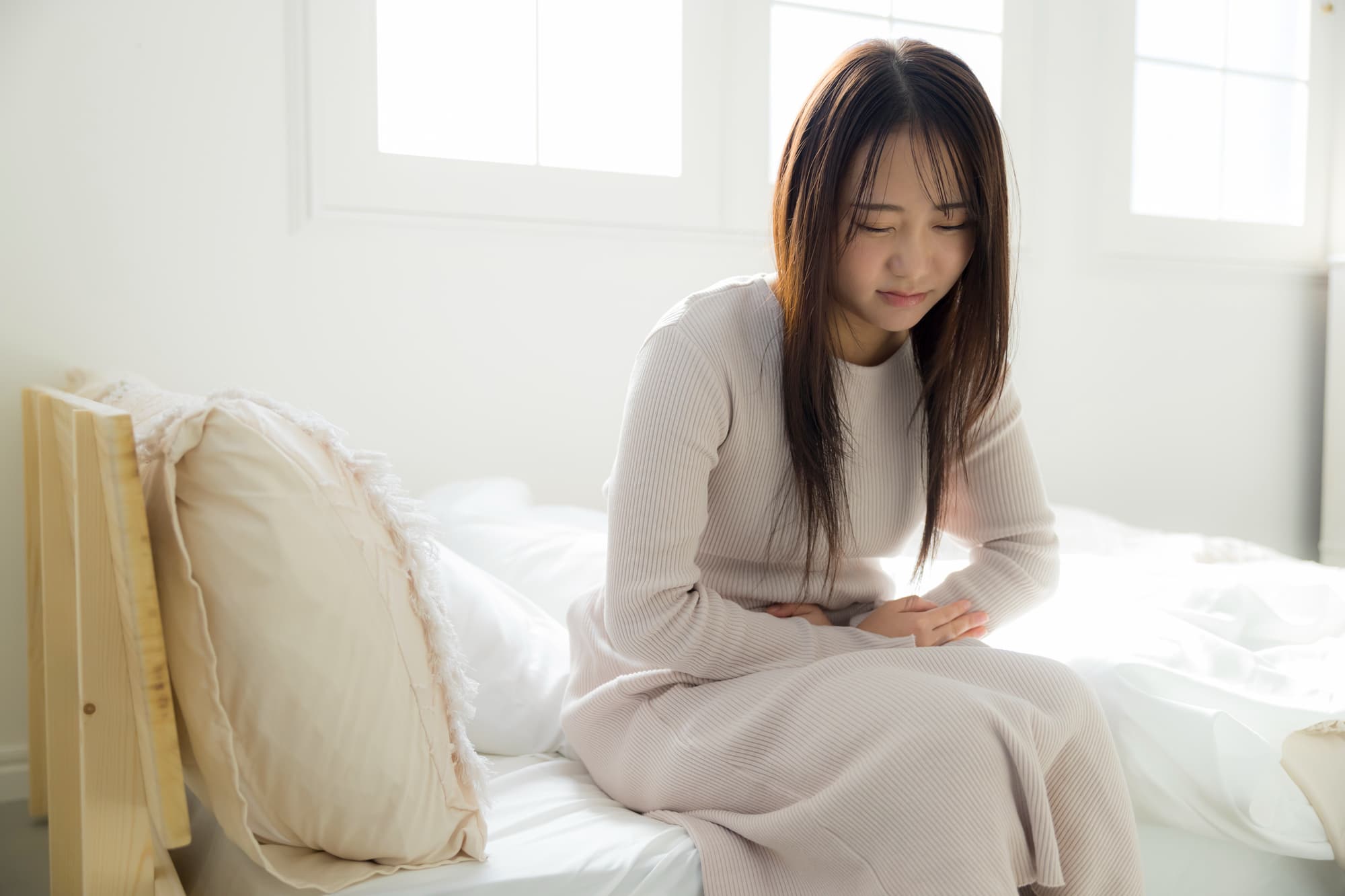 生理の腹痛に耐える女性