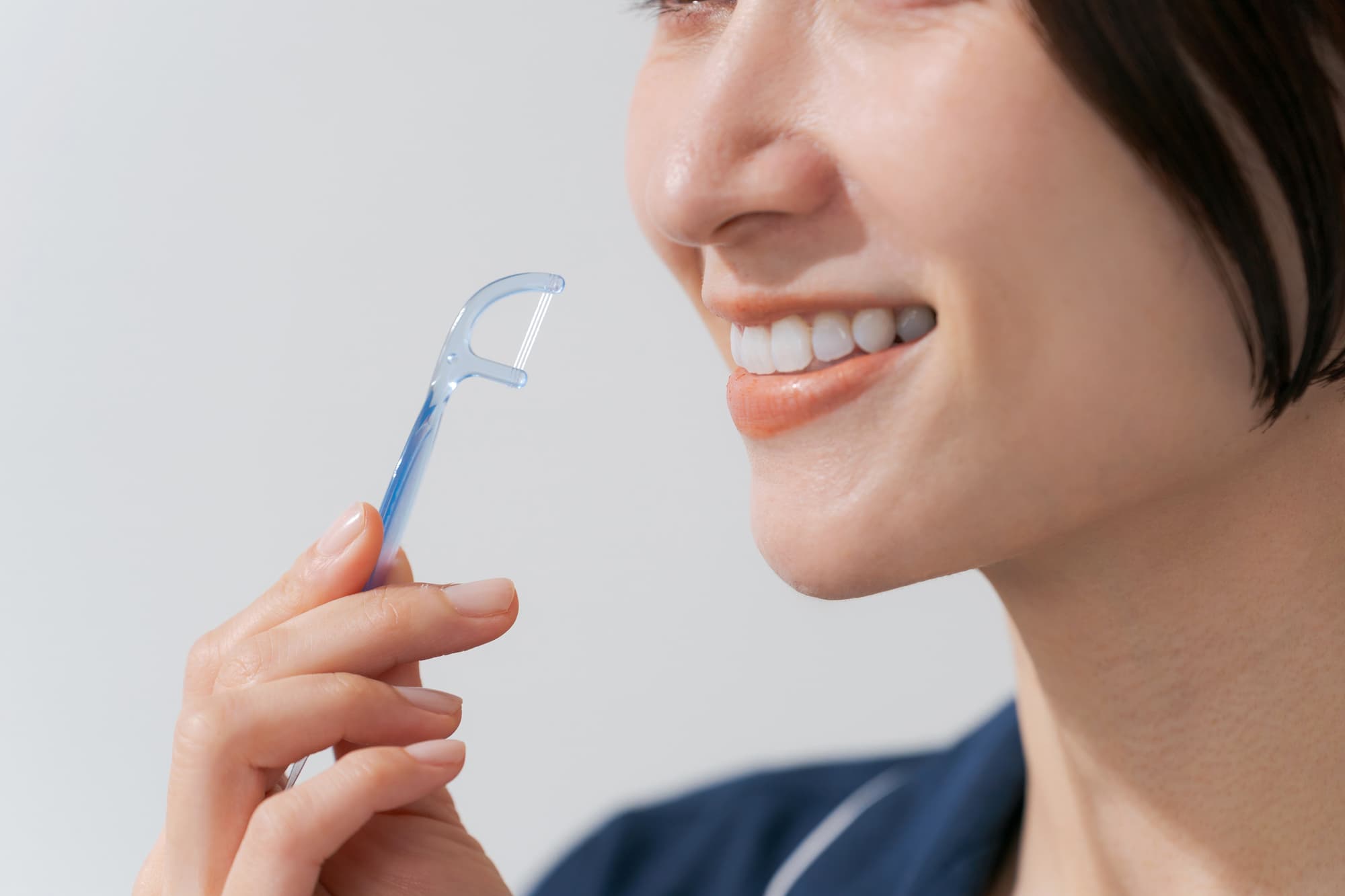 デンタルフロスを使用する女性