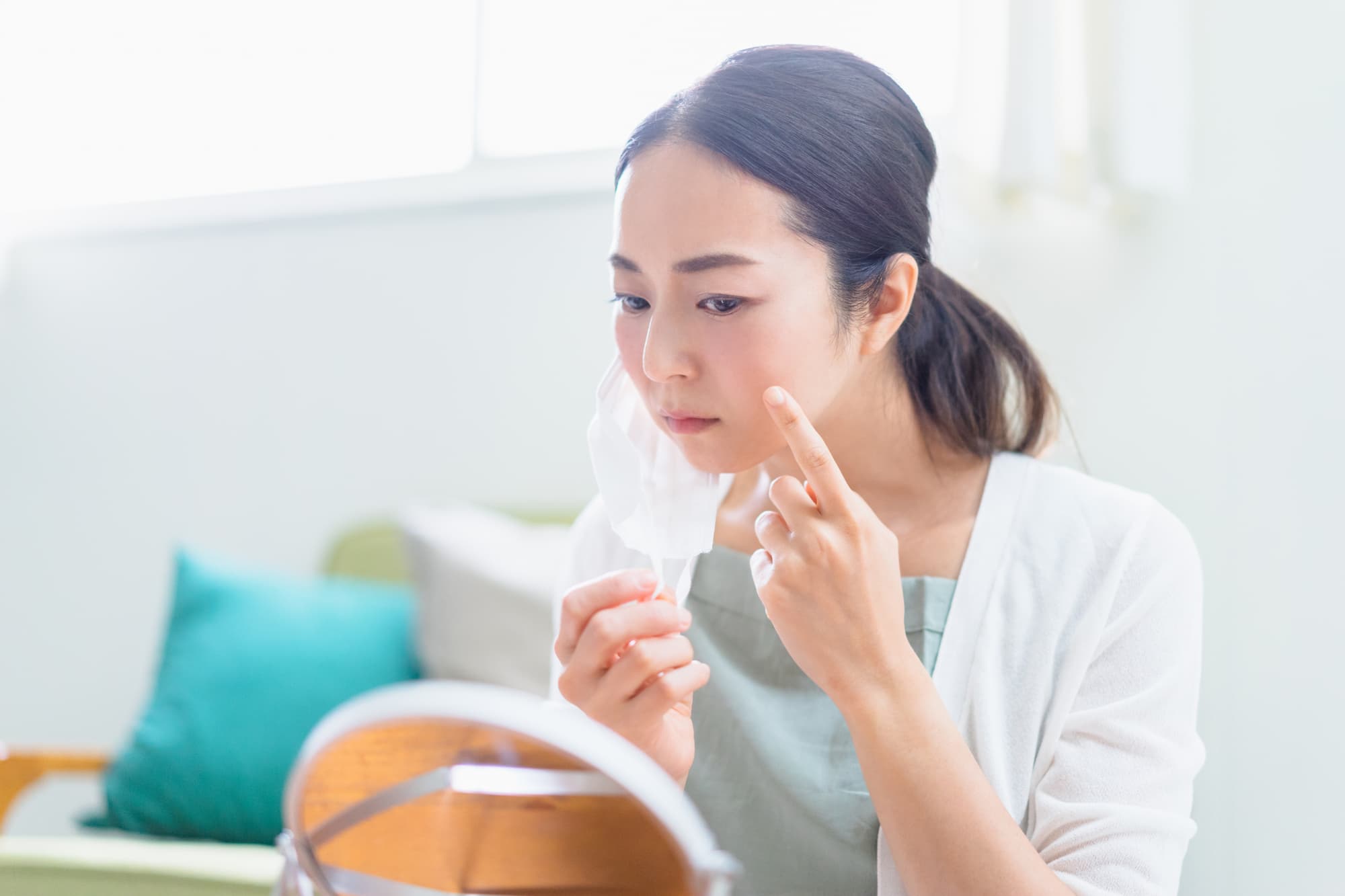 ニキビを鏡で確認する女性