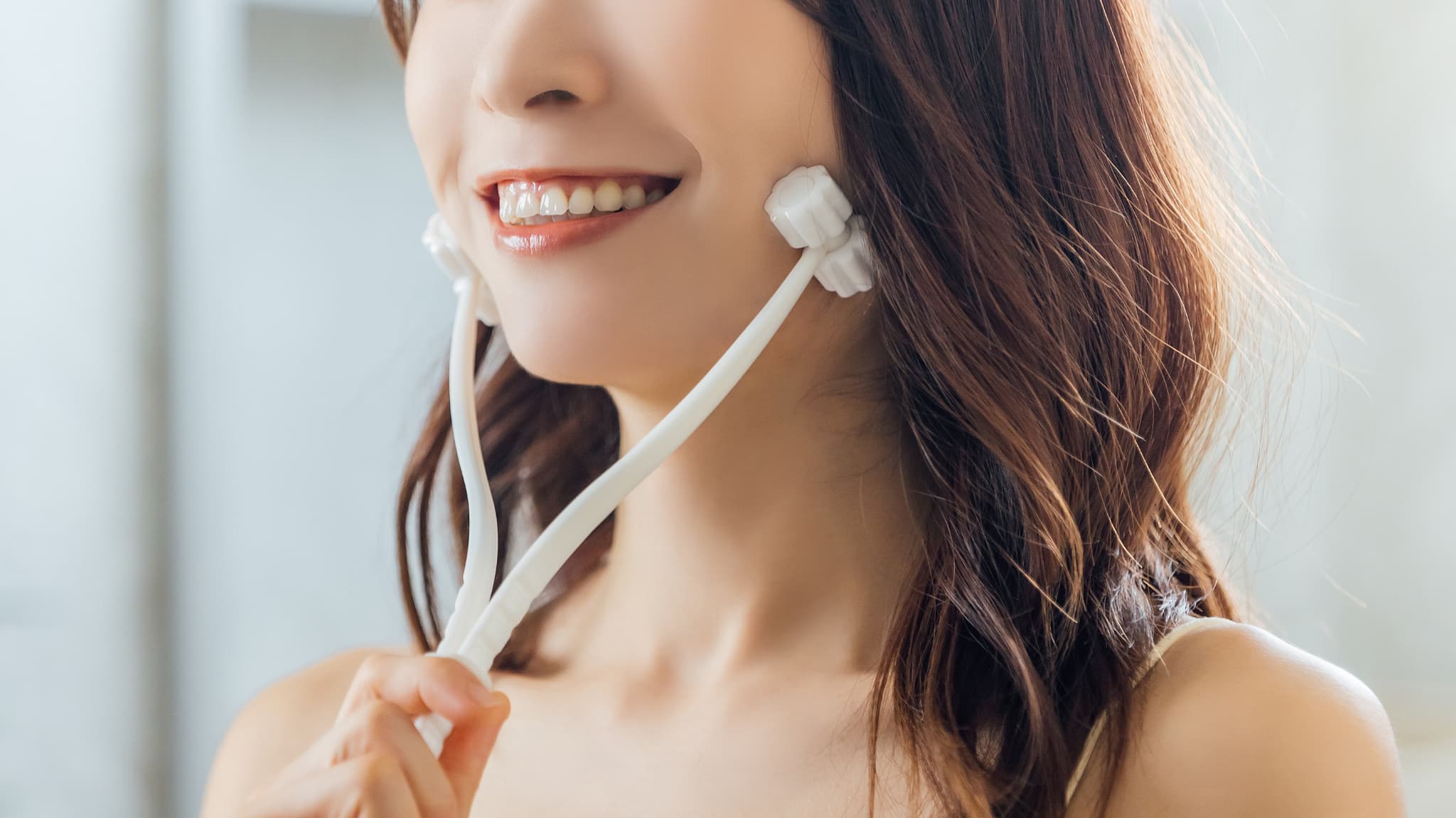 顔のマッサージでむくみをとる女性