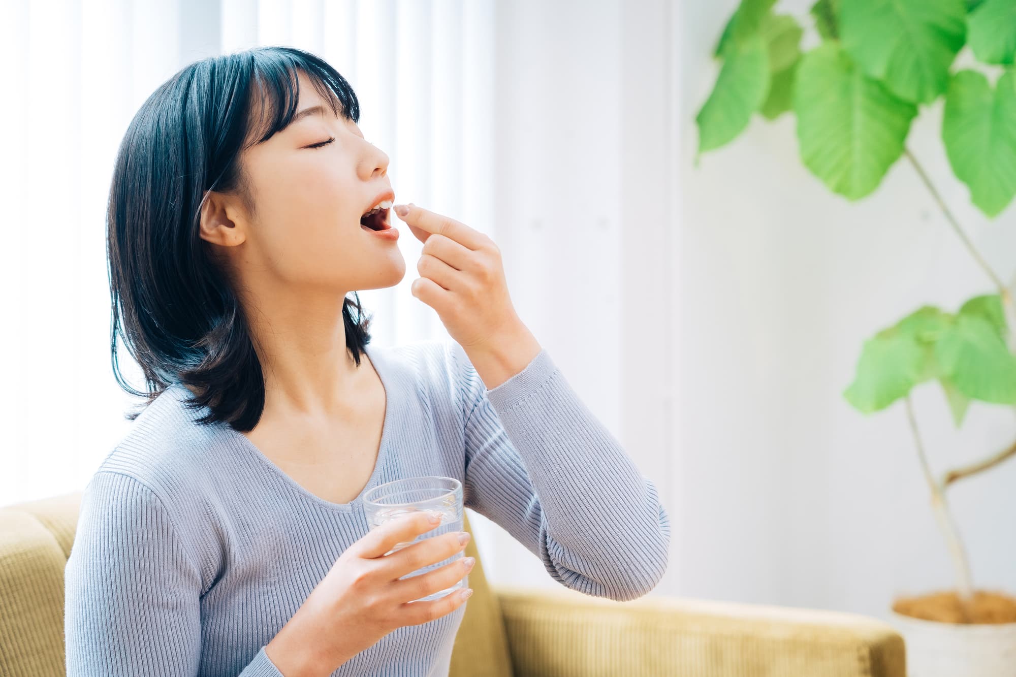 薬を飲む女性