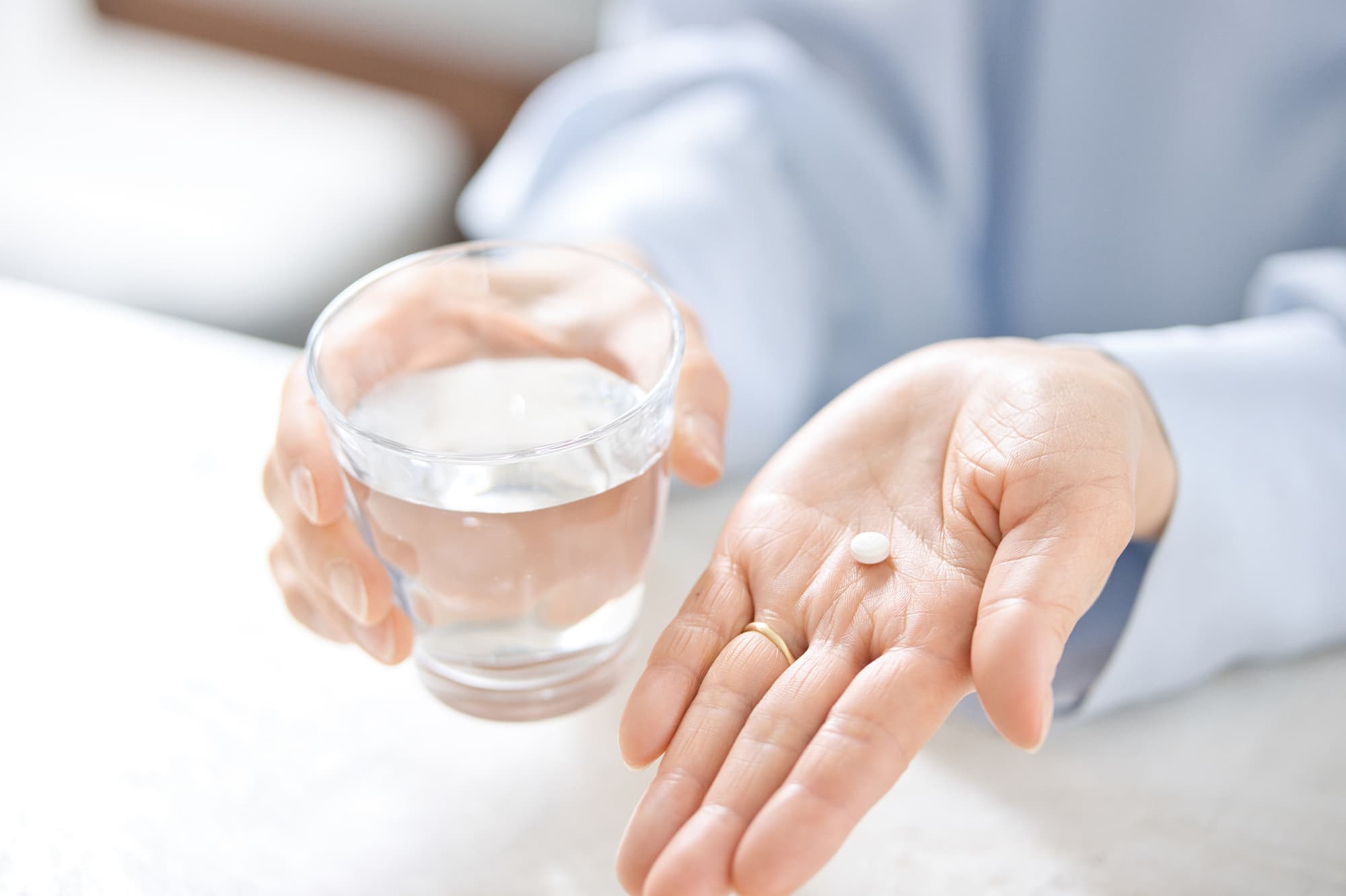 鎮痛剤を飲む女性の手