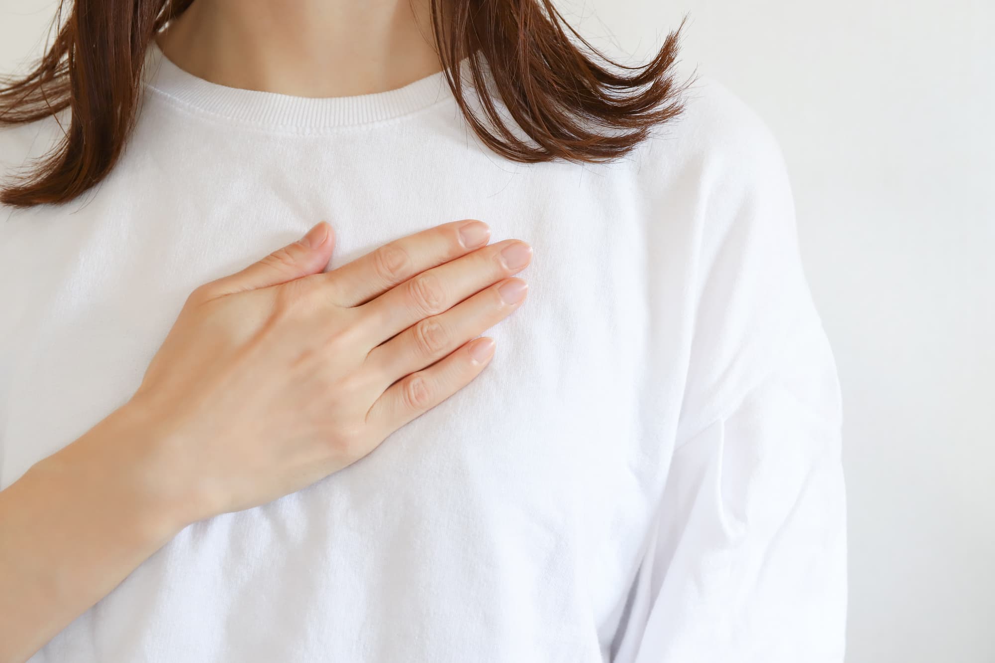 緊張して胸に手を当てる女性